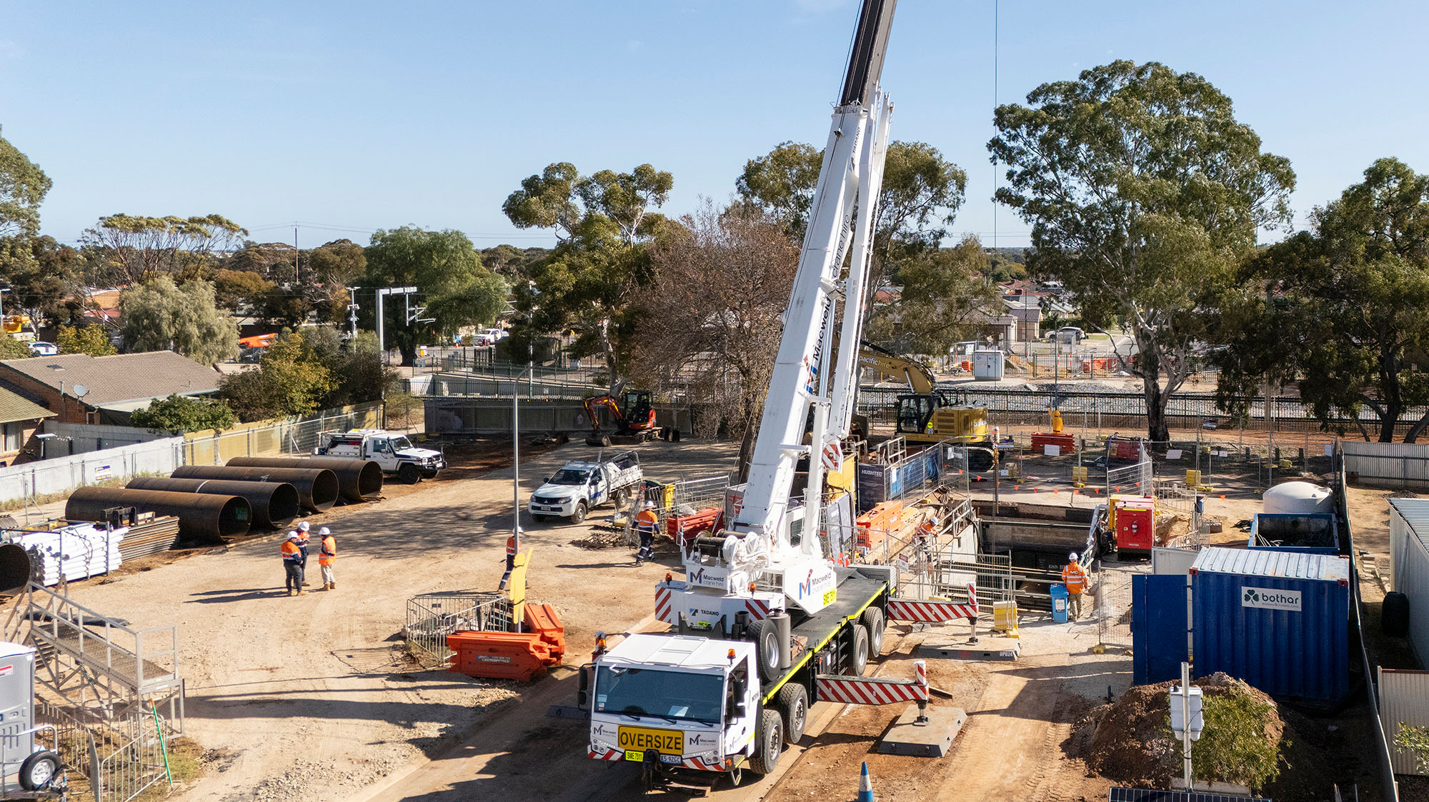 Large water main being delivered by crane to a large vacant block in Adelaide's north.
